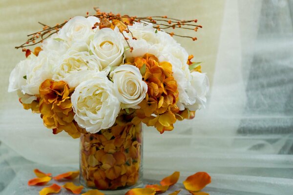 Ein orange-weißer Blumenstrauß in einer Vase auf dem Tisch
