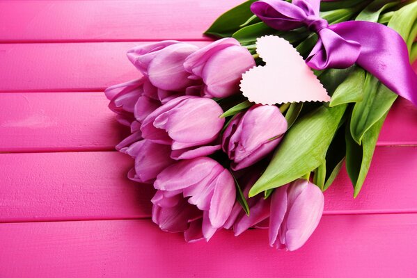 Delicate pink tulips with a postcard