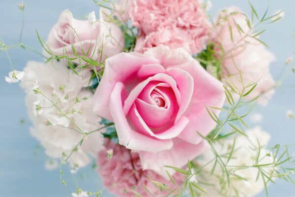 Un ramo de flores Rosadas y blancas sobre un fondo azul