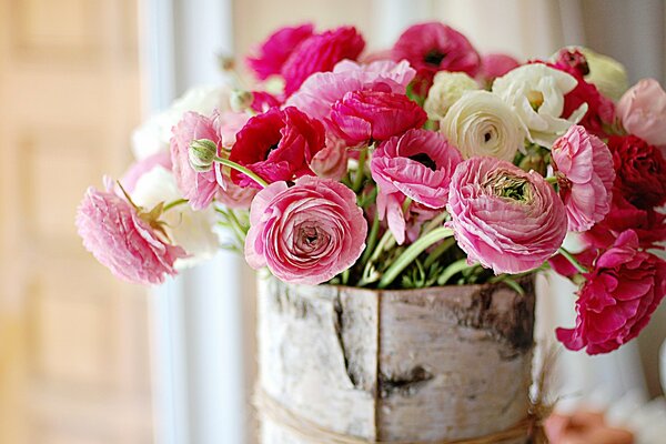 Нежнейший ярко-розовый букет удивительной красоты цветов в корзине из бересты на светлом коричневом фоне