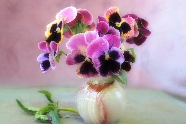 A vase with a bouquet of violets on the table