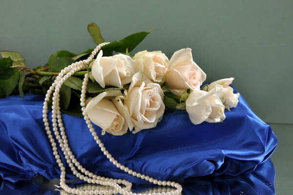 White roses lie on blue silk