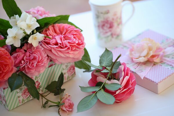 Boîte avec cadeau, tasse et roses sur la table