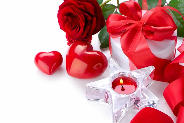 A beautiful gift, a gift with a red ribbon, red roses, a candle in the shape of a star