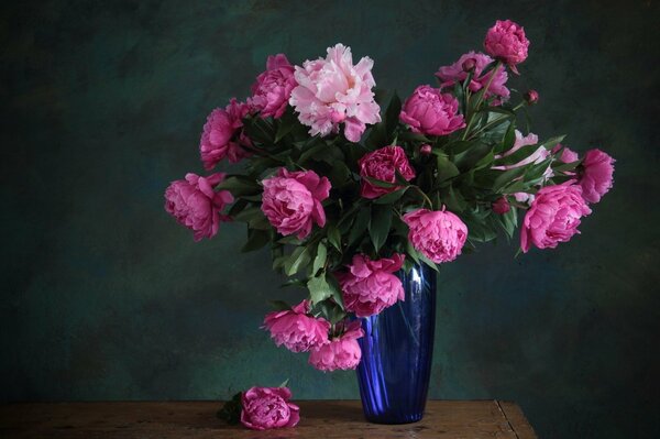 Bouquet composto da peonia rosa in piedi in un vaso blu