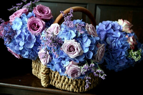 Three blue bouquets of roses in a basket