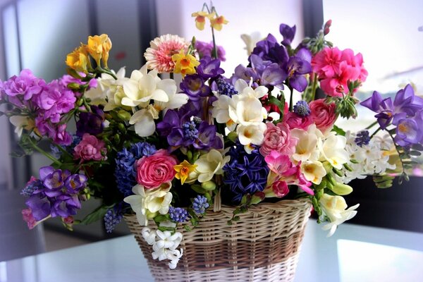 Korb mit einem üppigen Blumenstrauß in verschiedenen Farben