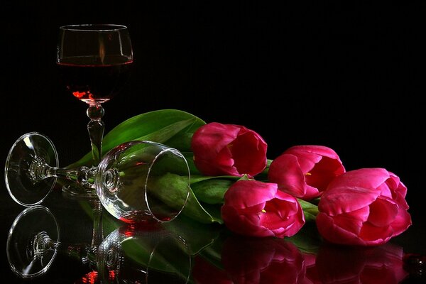 An elegant still life. Pink tulips and glasses of wine