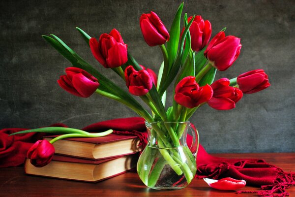 Rote Tulpen in einer Vase auf einem Tisch mit Büchern