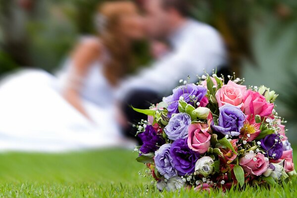 Bouquet of bright flowers on the background of the newlyweds