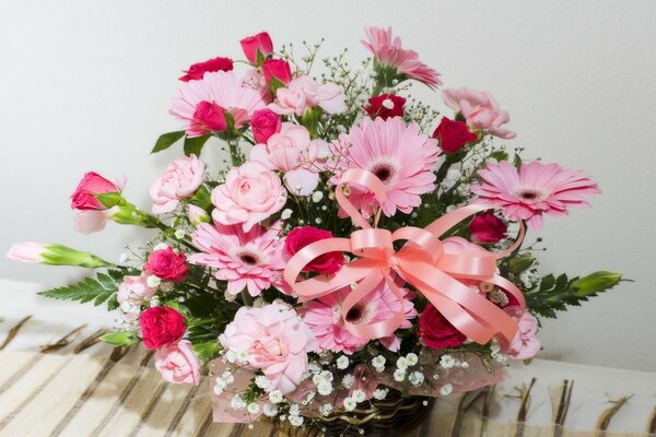 Fleurs roses dans un panier avec ruban