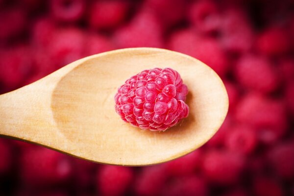 Raspberry berry on a wooden spoon