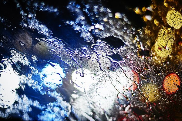 Lumières de la ville de nuit sur verre mouillé