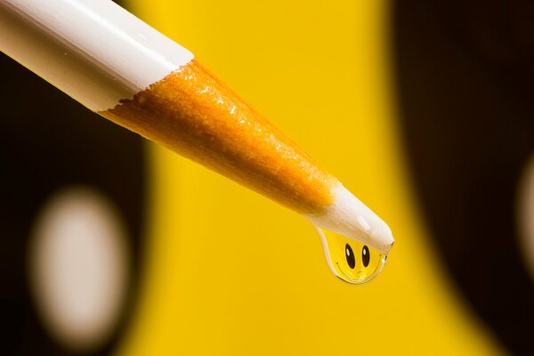 Smiley face in the form of a drop on a pencil