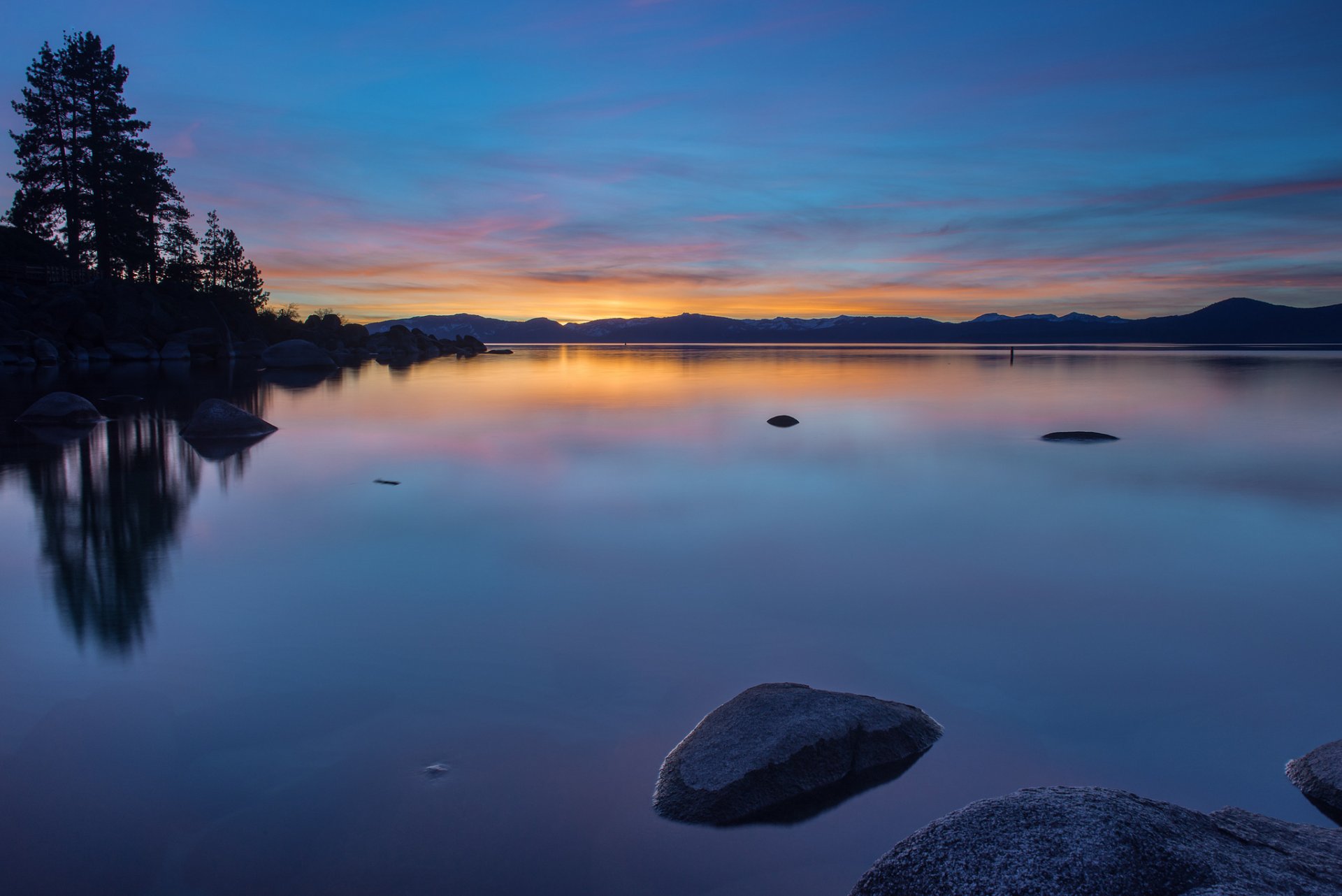 united states lake water surface of reflection beach stones tree night orange sunset blue sky