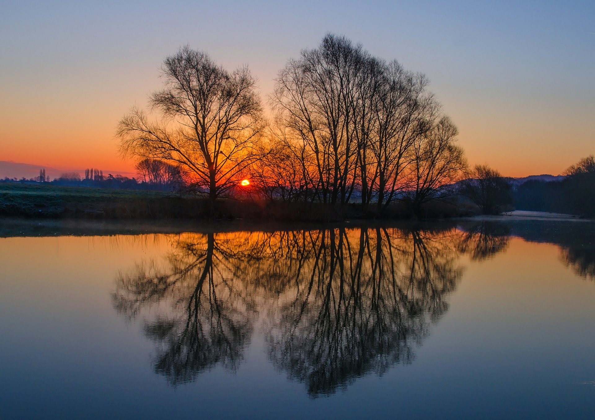 regno unito inghilterra sera radura alberi sole tramonto cielo fiume acqua superficie liscia riflessione