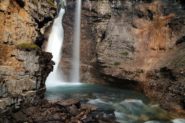 A smoky waterfall in the rocks. Beautiful nature