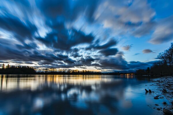 Orilla del lago al atardecer con nubes