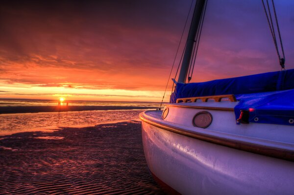 Piękny zachód słońca nad morzem i biały jacht