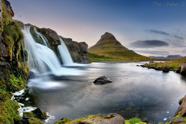 Mountain waterfalls in Iceland on the background of a volcano and a lake