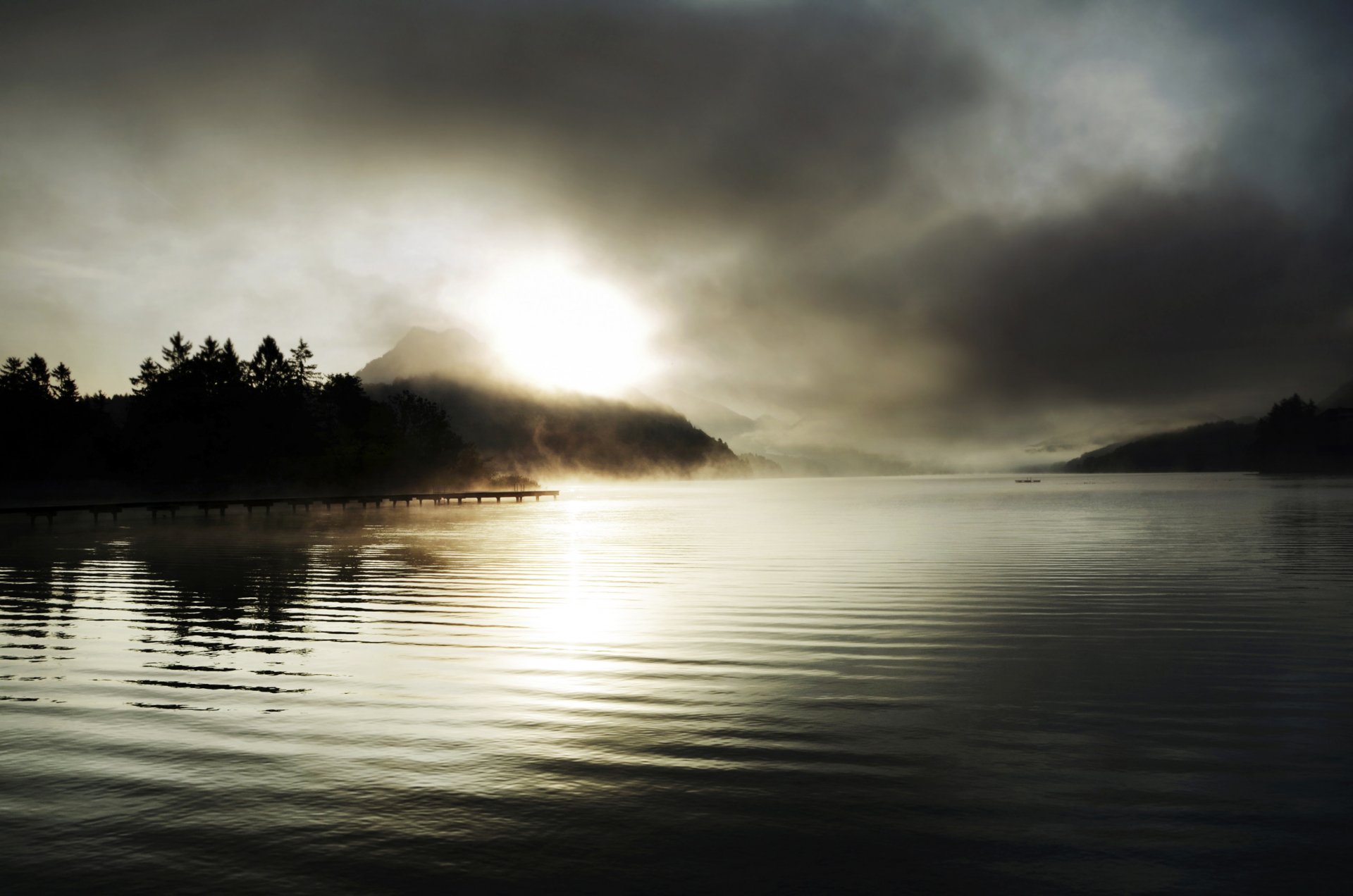 fog pier lake mountain sun rays sunset tree spruce