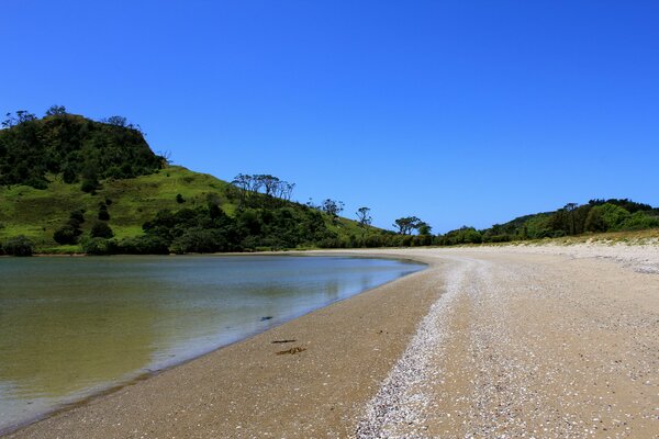 Sandy lake shore near hills