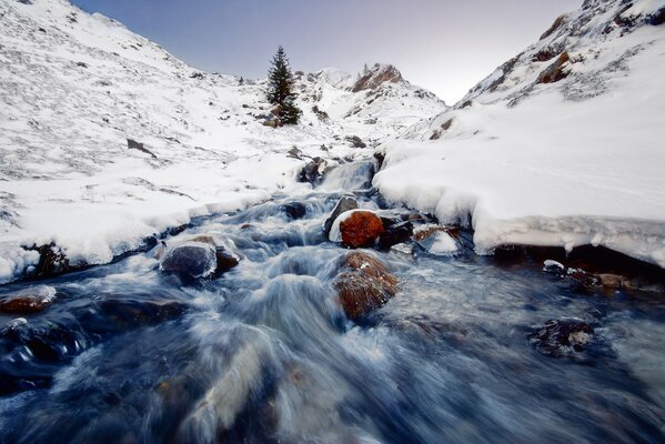 Bergfluss im Winter in den Felsen