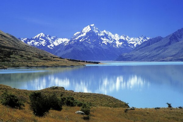 High mountains with snowy tops and with a beautiful view of the lake at the foot and nature