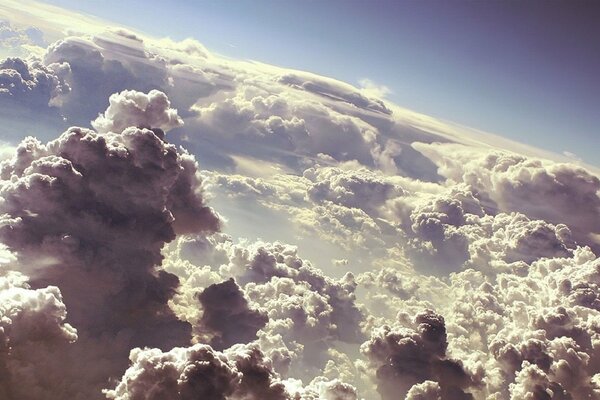 Wolken über dem Boden, von der Sonne beleuchtet, Blick aus dem Flugzeug