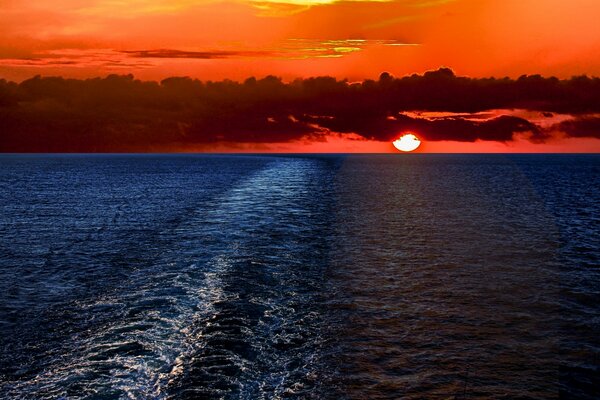 Sun and clouds on the background of sunset in the sea