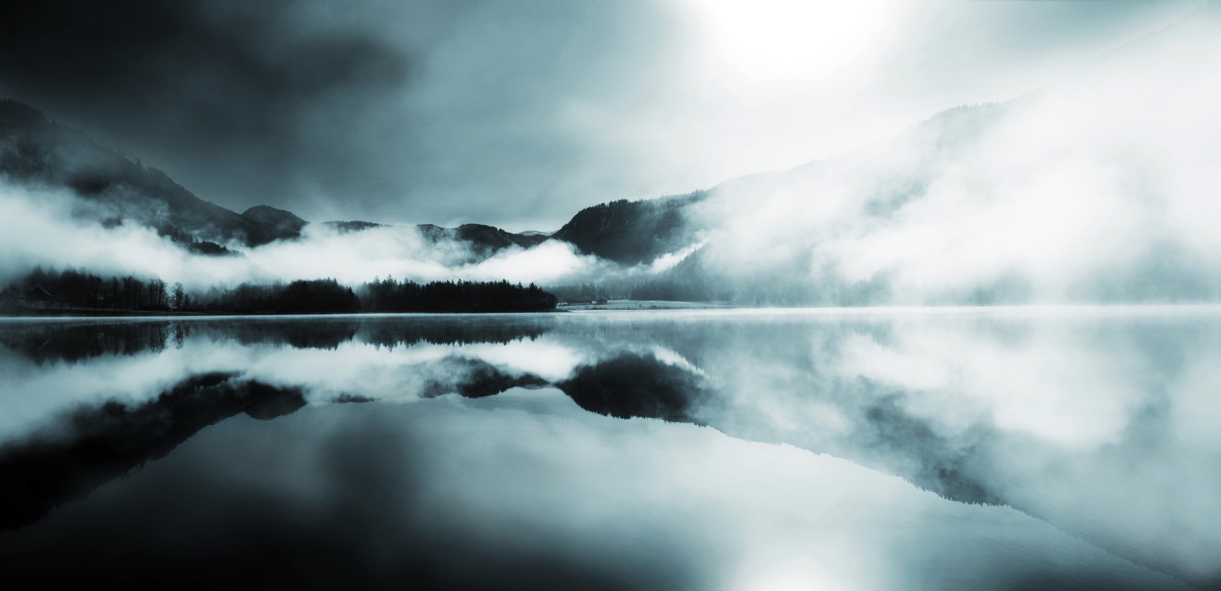 fog mountain hills forest conifers lake surface of reflection