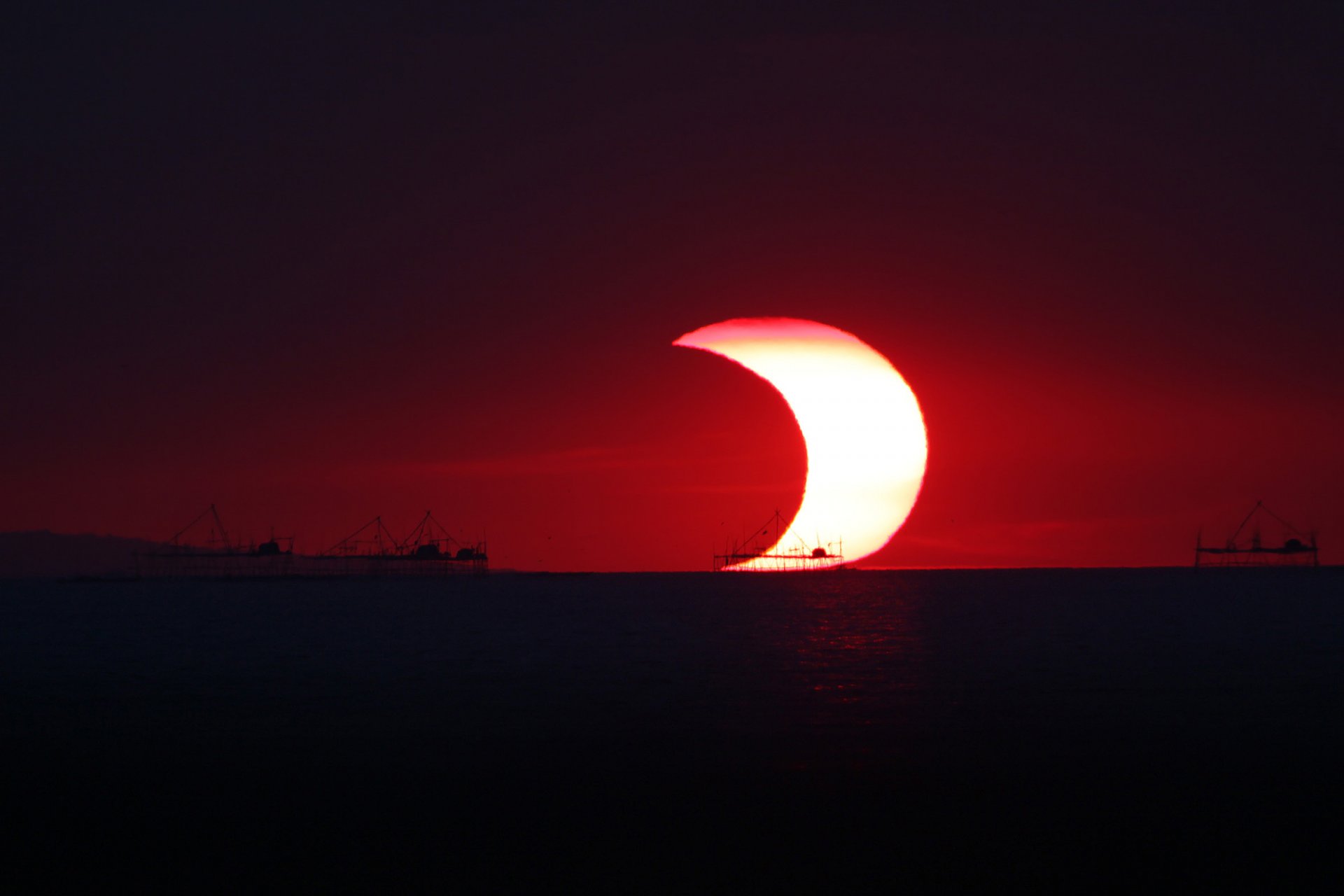 un moon eclipse a partial ocean horizon