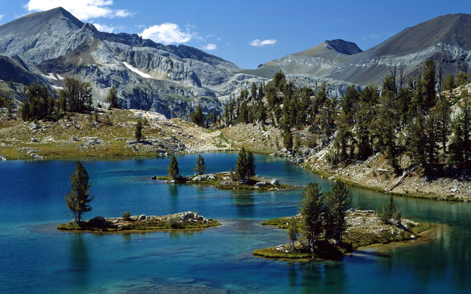 rocce montagne cime pendio foresta alberi fiume letto isolotti corrente isole cielo nuvole