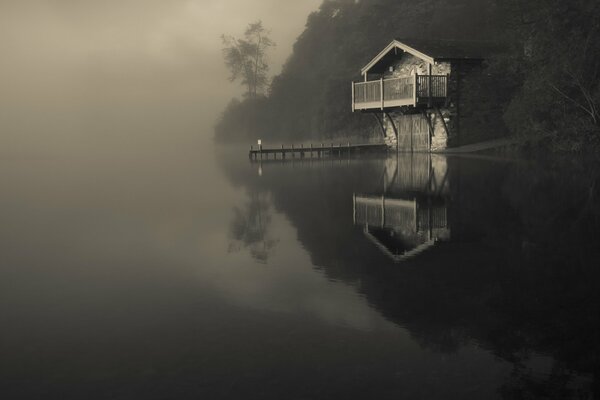 Haus am Ufer im Nebel