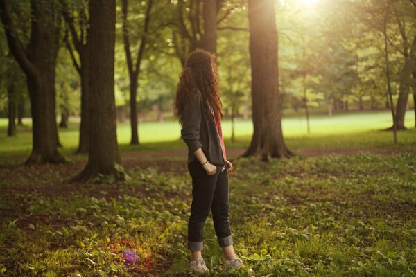 Mädchen in der Natur zwischen Bäumen und Gras