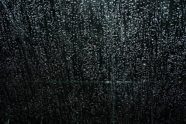 Gouttes de pluie de nuit sur la vitre