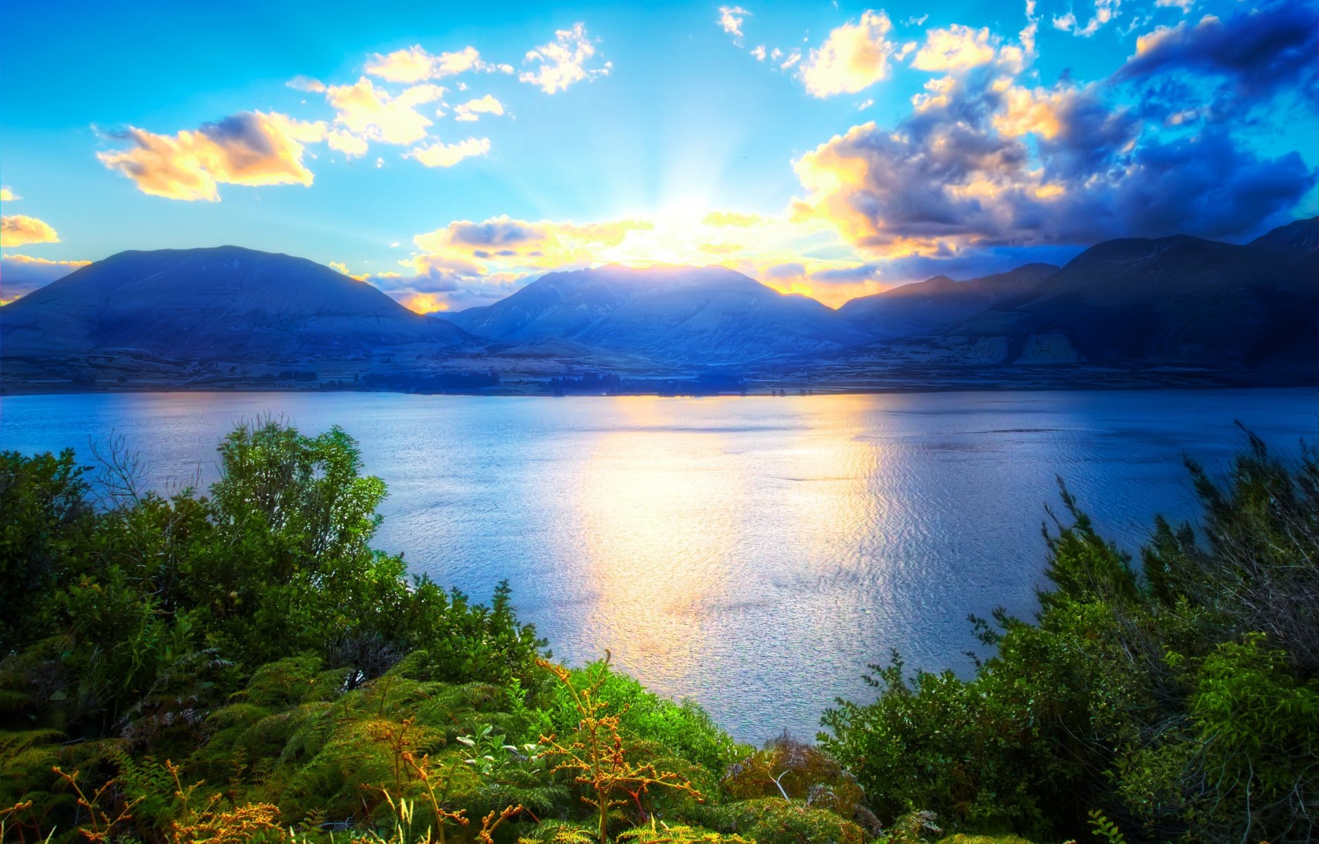 nature water lake mountain sky clouds sun green plants grass beautiful