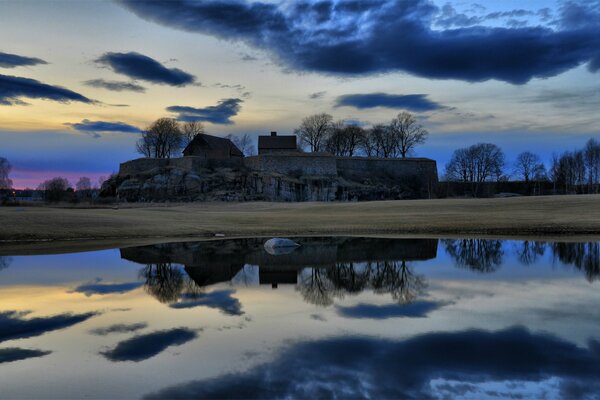 The sunset sky is reflected in the surface of the water