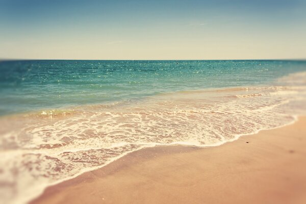 Light sea waves on a deserted beach