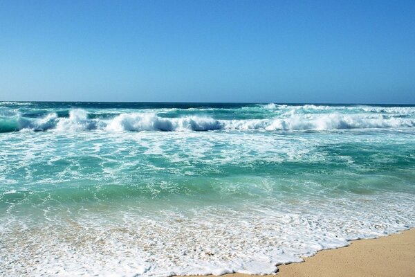 Strand am Meer mit Wellen im Sand