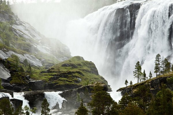 Waterfall near green mountains and trees