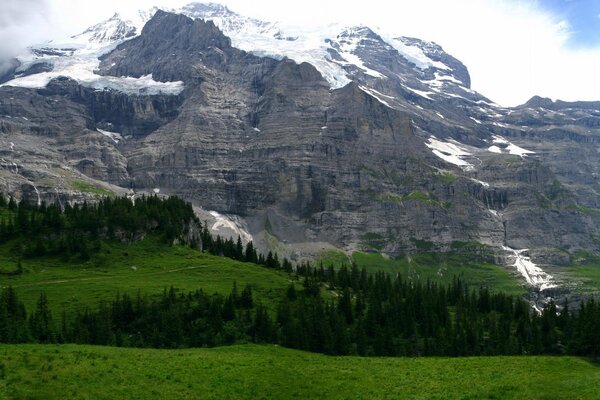 Montagnes enneigées sous un ciel nuageux