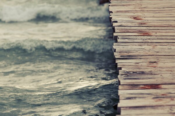 Cold waves of water swing under a wooden platform