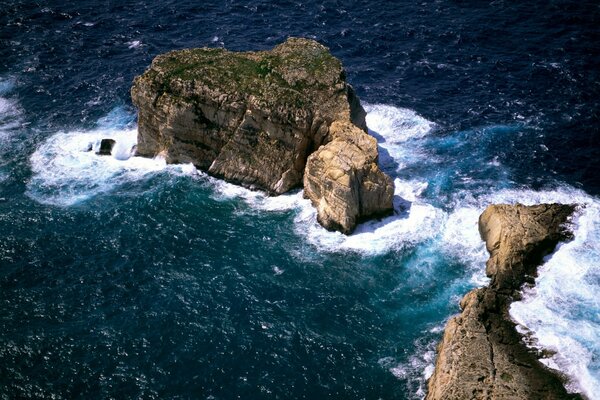 Rocky island in the shape of a heart on the background of the sea