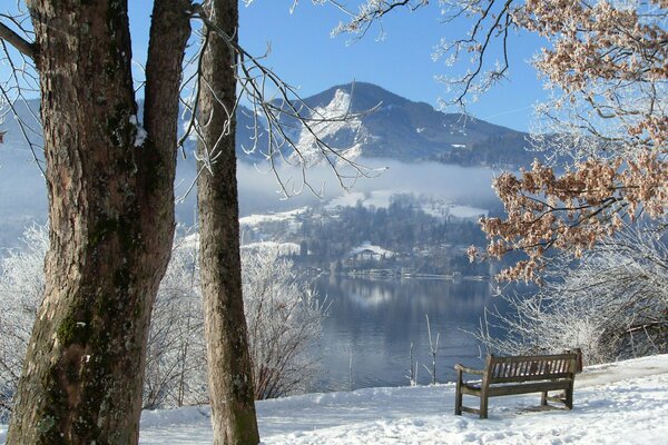 Bench on the shore of a snowy lake