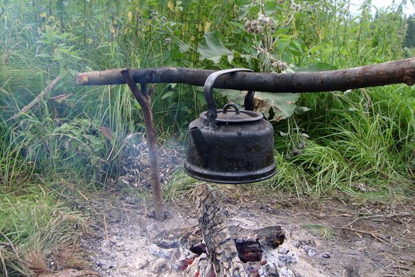 Ein Lagerfeuer in der Taiga und ein schwarzer Wasserkocher