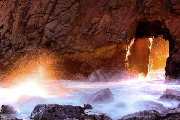 Poste brillante de la luz a través de la gruta Marina en el espray de agua