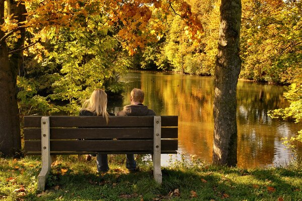 Chico y chica en un paseo en el parque de otoño de oro