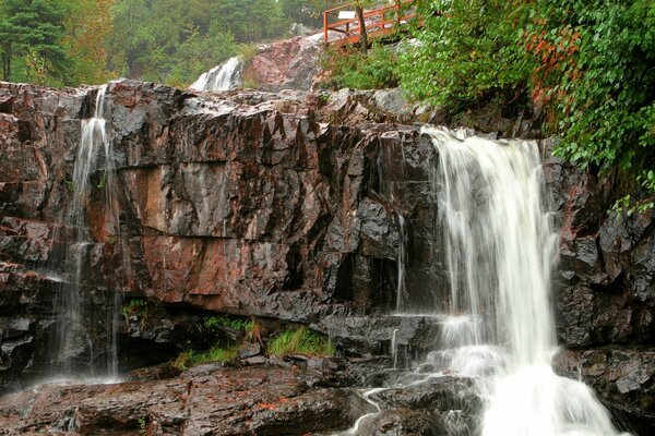 A bridge among the rocks, huge boulders at the waterfall