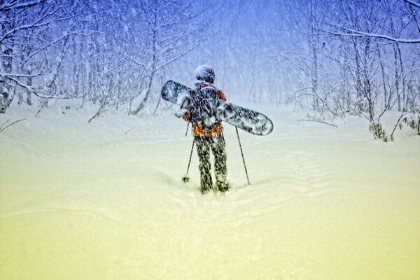 Человек в зимнем лесу на сноуборде